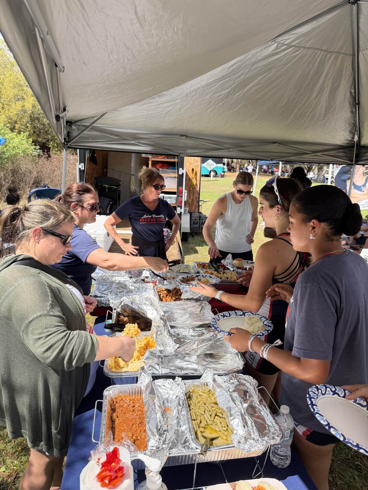 LBRA parent volunteers serving a hot meal at the team tent during a regatta