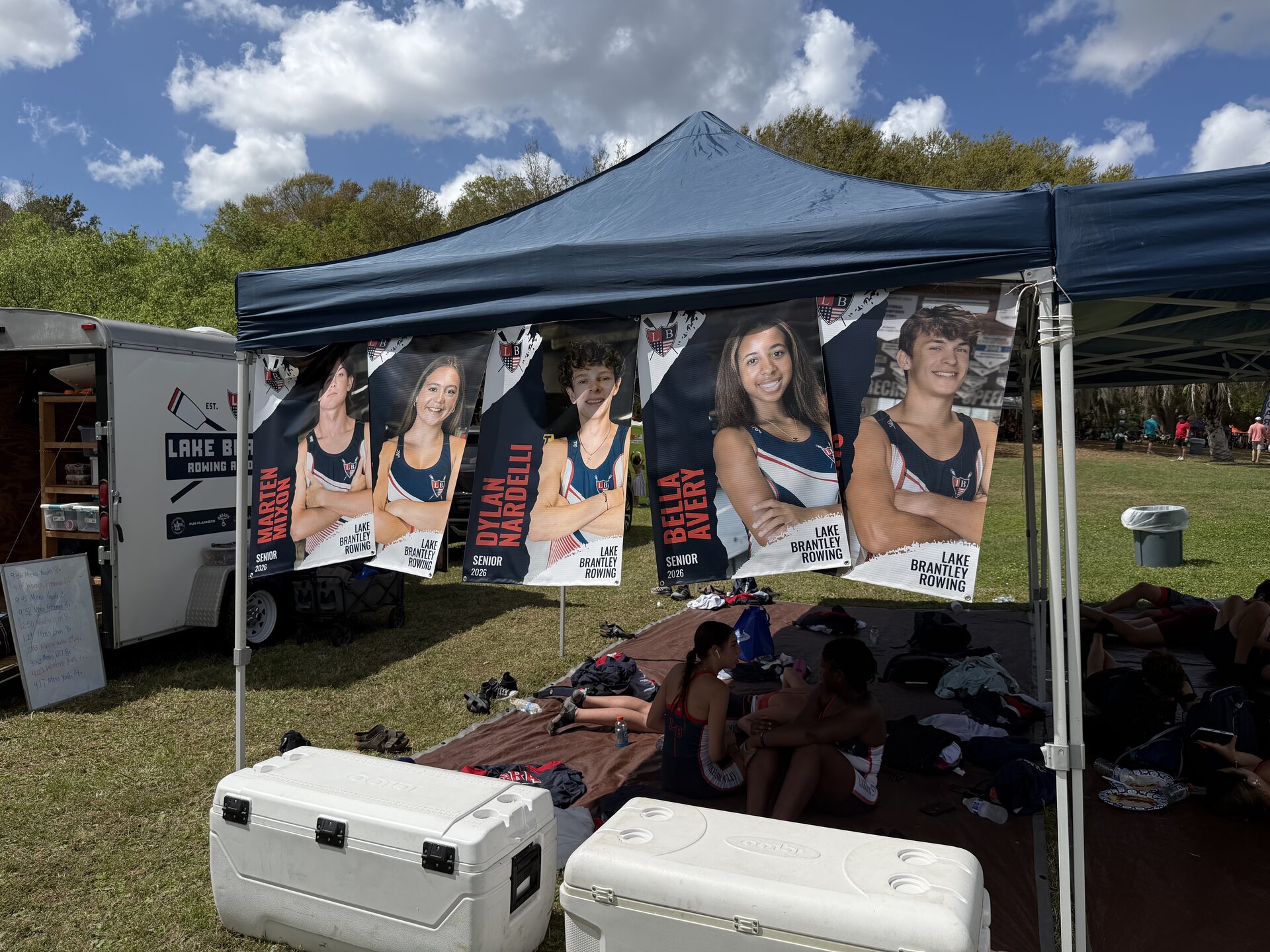 Senior class banners hanging from the LBRA tent at a regatta — Marten Mixon, Dylan Nardelli, Bella Avery